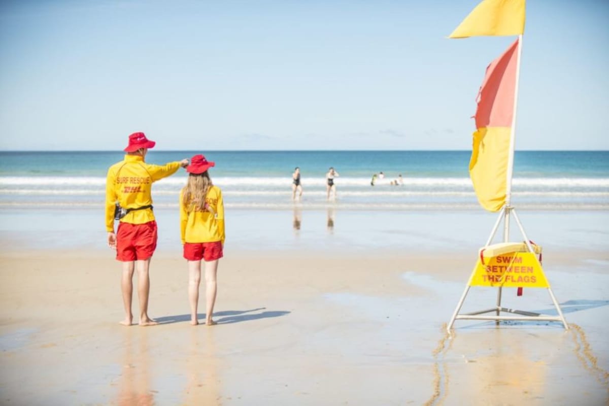 Two Surf Life Savers looking out onto the water