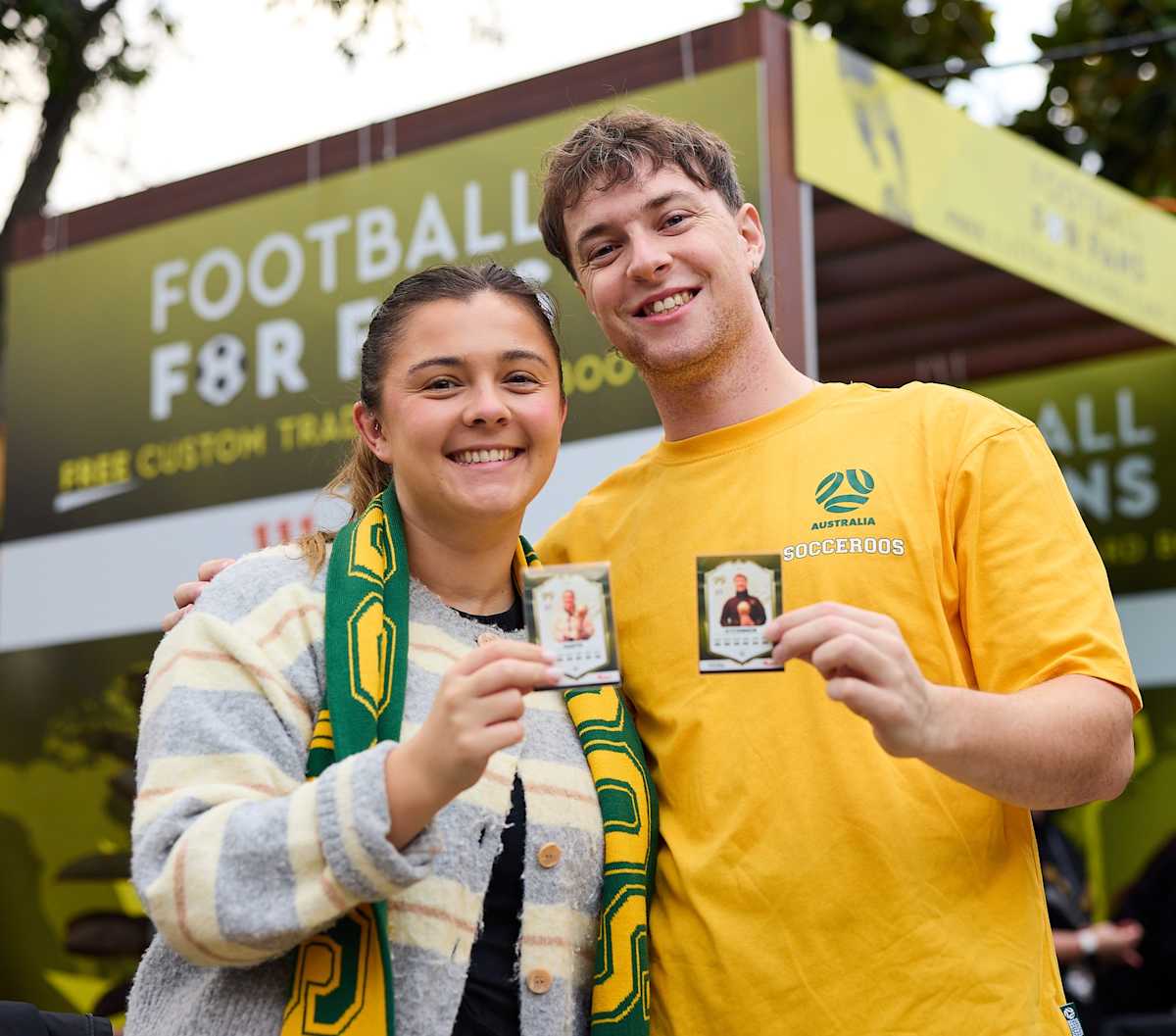 An image of two people holding their trading card images. 