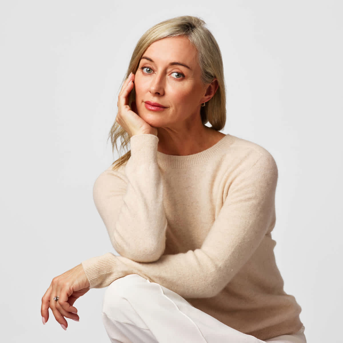 A lady wearing a white cashmere jumper