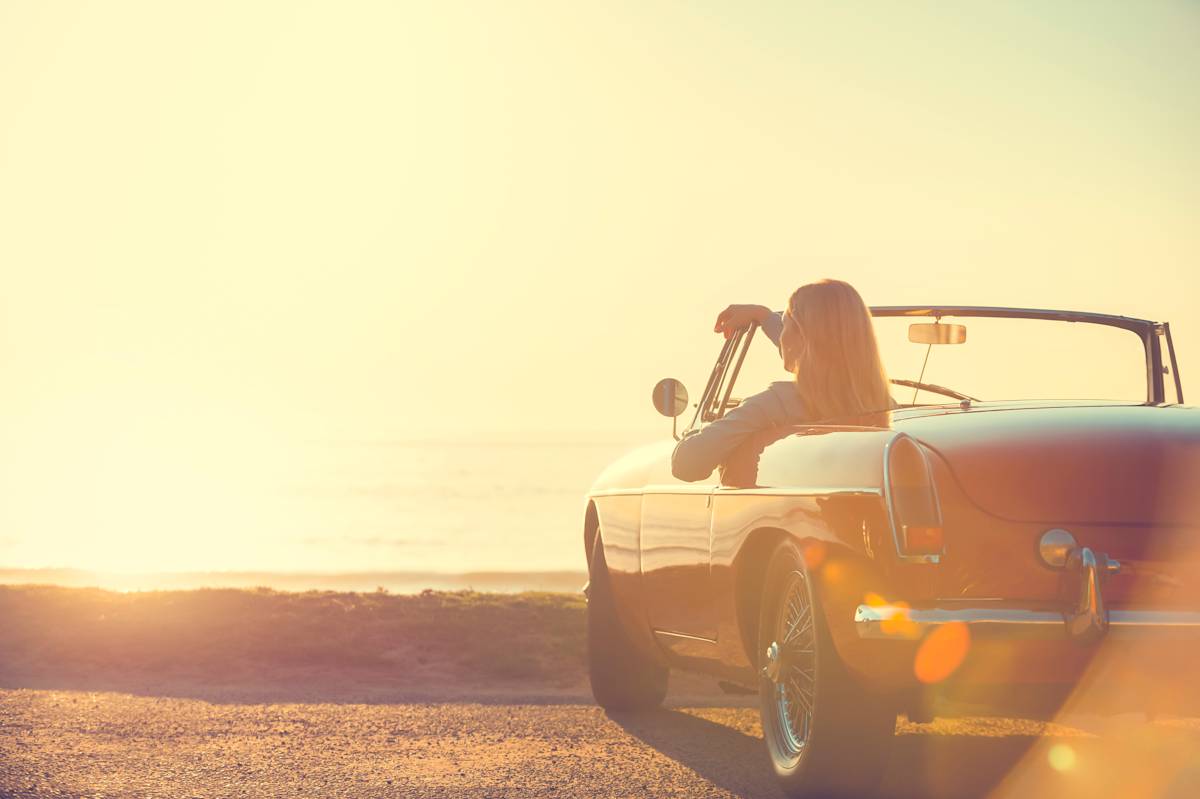 Man and woman driving in convertible