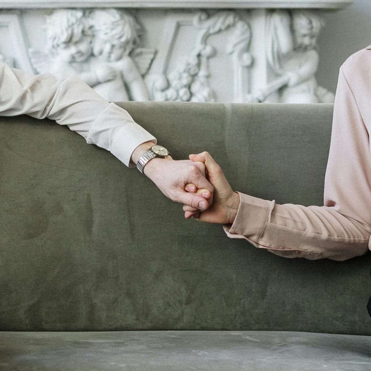 Two people holding hands in support