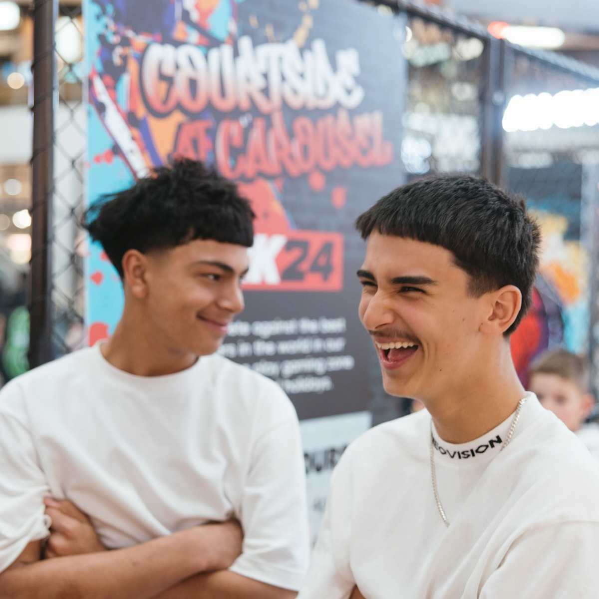 Two young adults laughing in front of basketball court activation