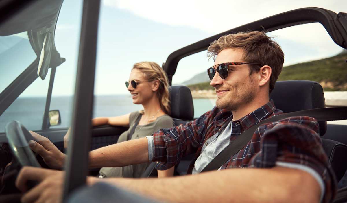 Man and woman driving wearing sunglasses