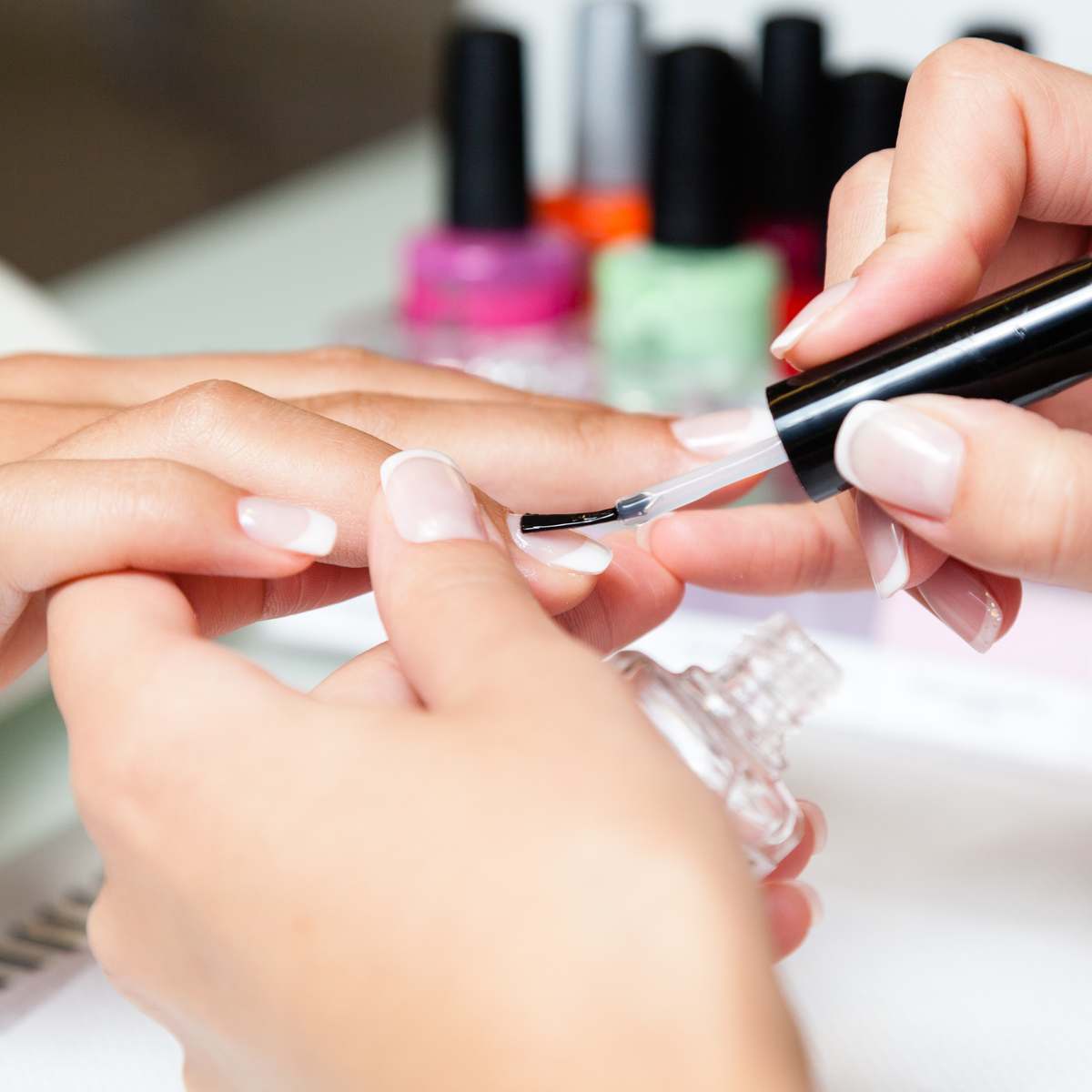 Image showing a manicure with different coloured nail polish bottles,