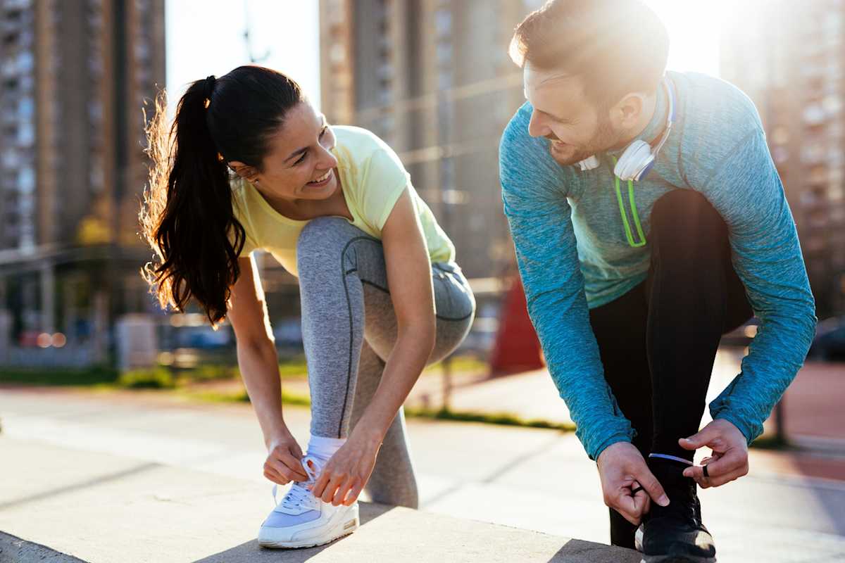 Man and woman in activewear tying their runners