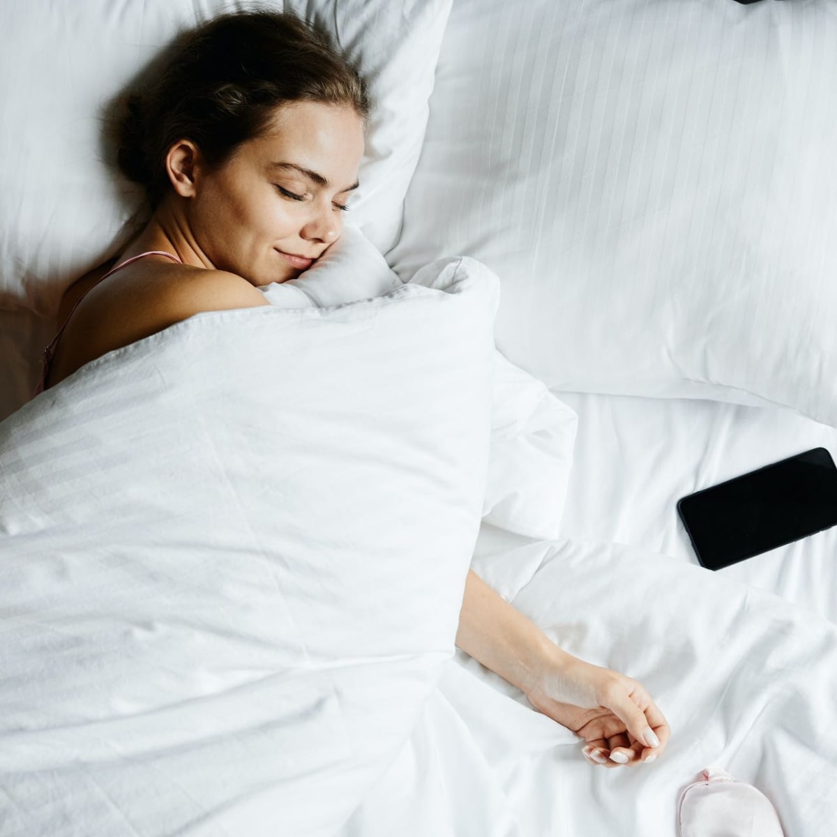 a lady asleep in her bed with the duvet covering her