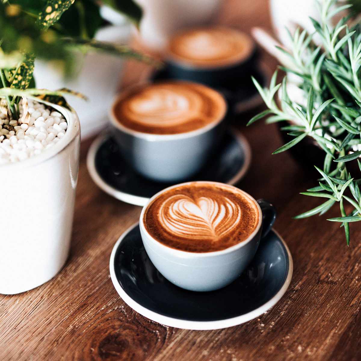 Person pouring milk into a coffee