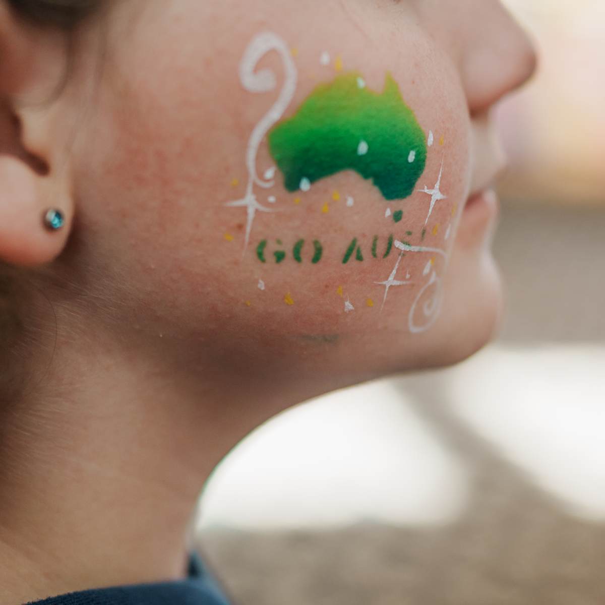 Child with Australia and 'Go Aus' painted on their cheek