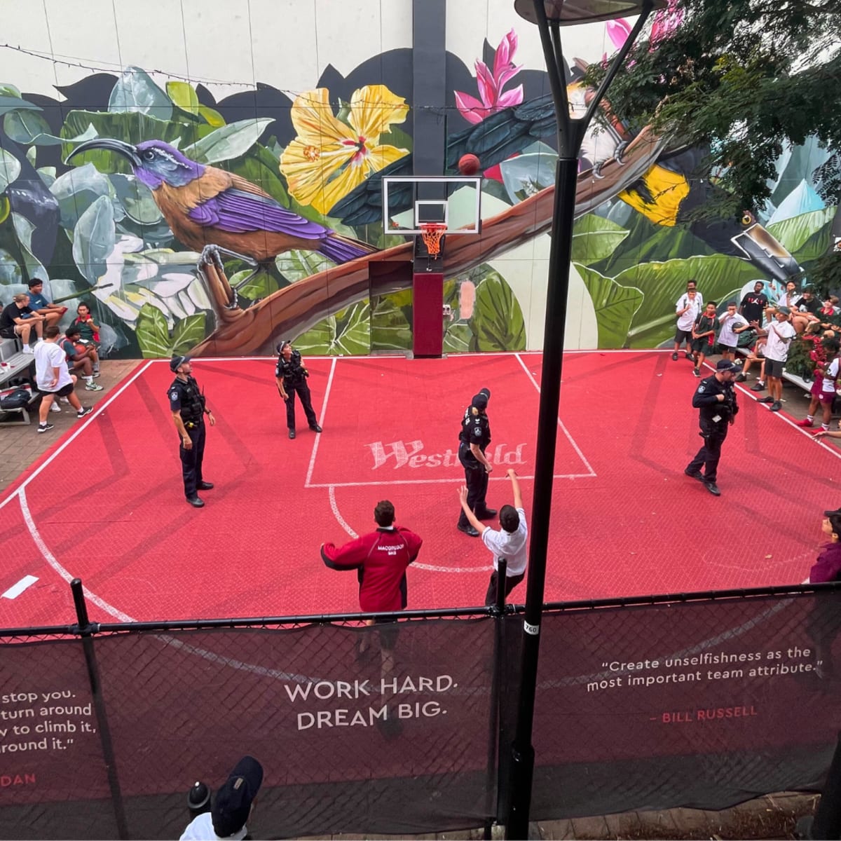 Kids and police officers playing basketball.
