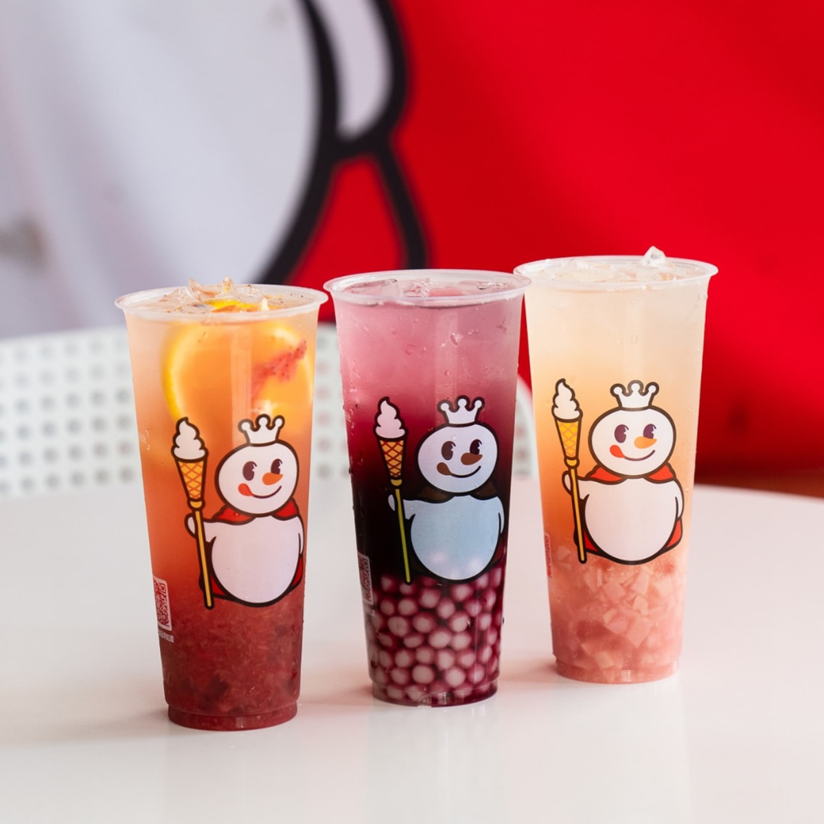 Mixue bubble tea lined up on a table with a blurred background.