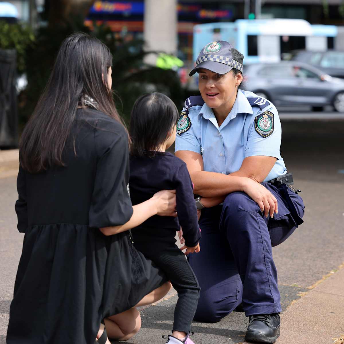 Female police officer talking with mother and child in Hyde Park