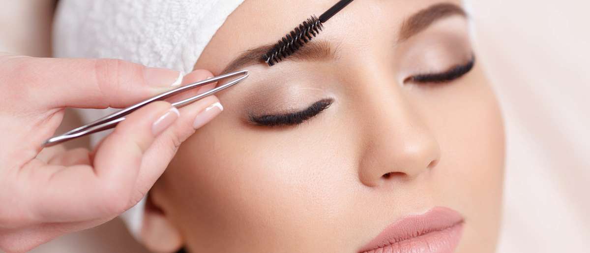 Woman having eyebrows groomed