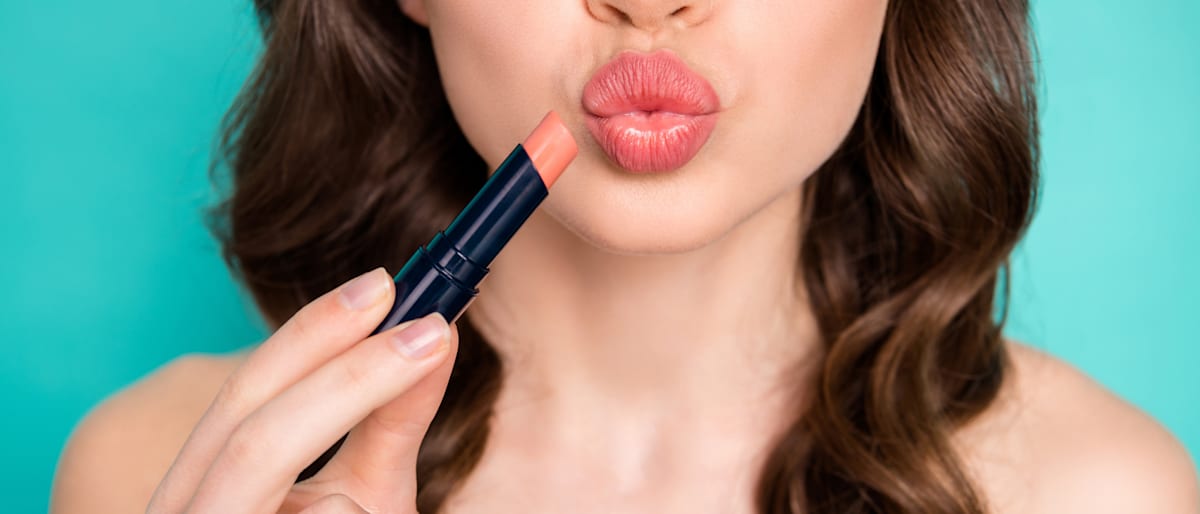 Woman applying lipstick.
