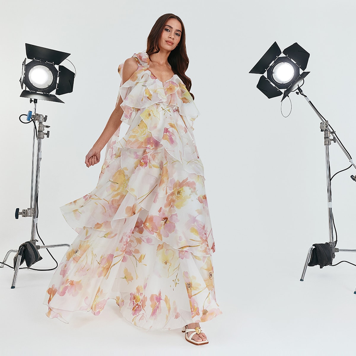 A woman walking in a sleeveless floral dress with ruffles