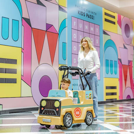 Kiddy Car driving past Kids Pass hoarding