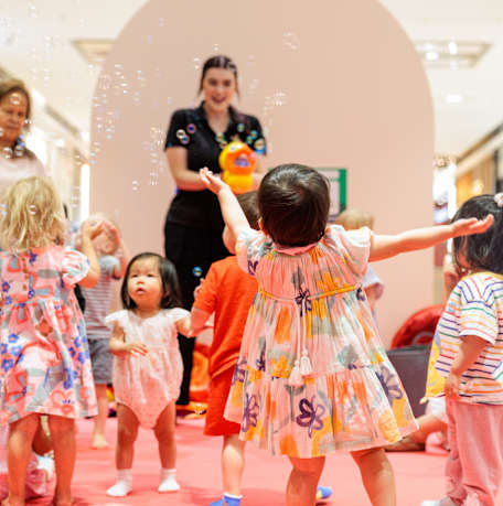 An image of kids playing with bubbles at Kids Mornings.