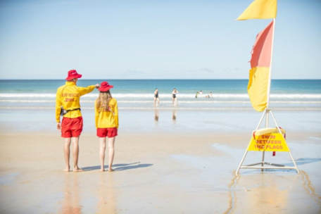 Two Surf Life Savers looking out onto the water