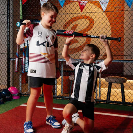 two kids holding up baseball bats at The Ballpark