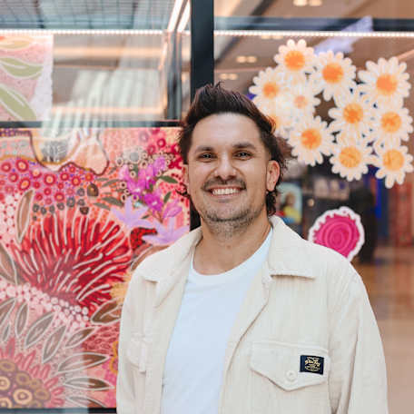 Alejandro Lauren (Wayde Clarke) standing in front of his art exhibition
