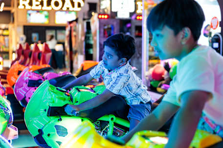 An image of two kids on a ride in iPlay Carousel. 