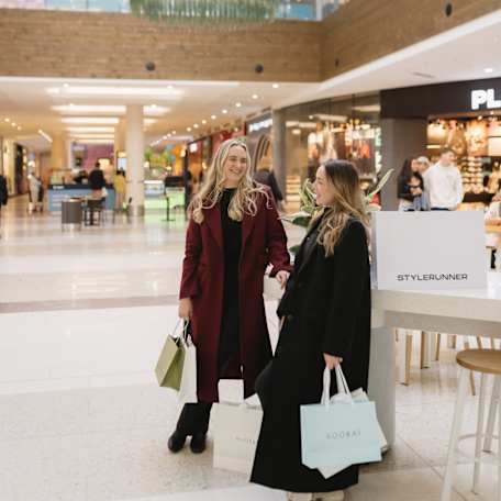 two women with multiple retailer shopping bags at westfield kotara