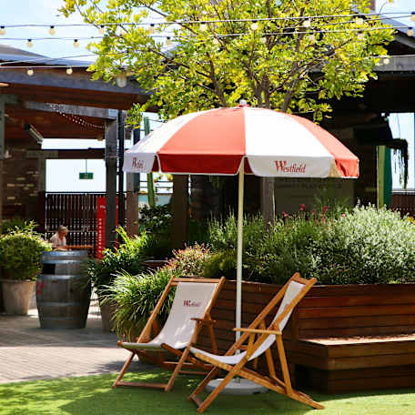 image of the deck chairs and umbrella on a sunny day on the rooftop