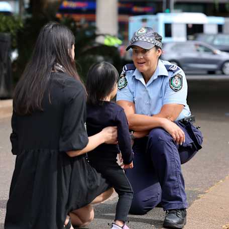 Female police officer talking with mother and child in Hyde Park